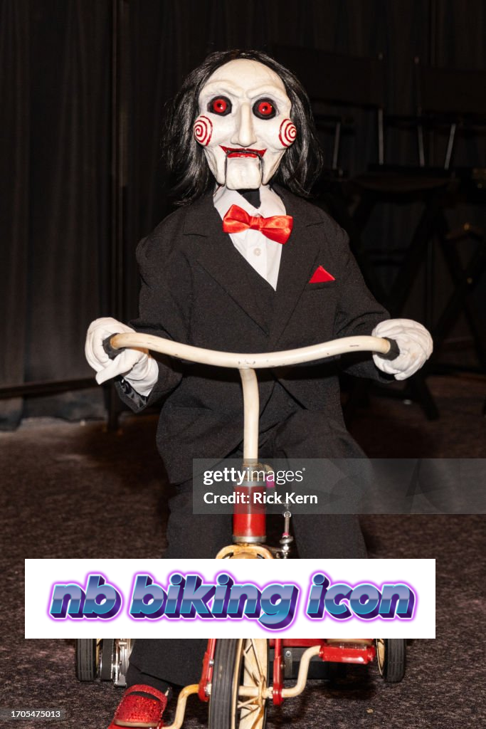 a marionette of the Jigsaw character from the Saw movie franchise on a tricycle